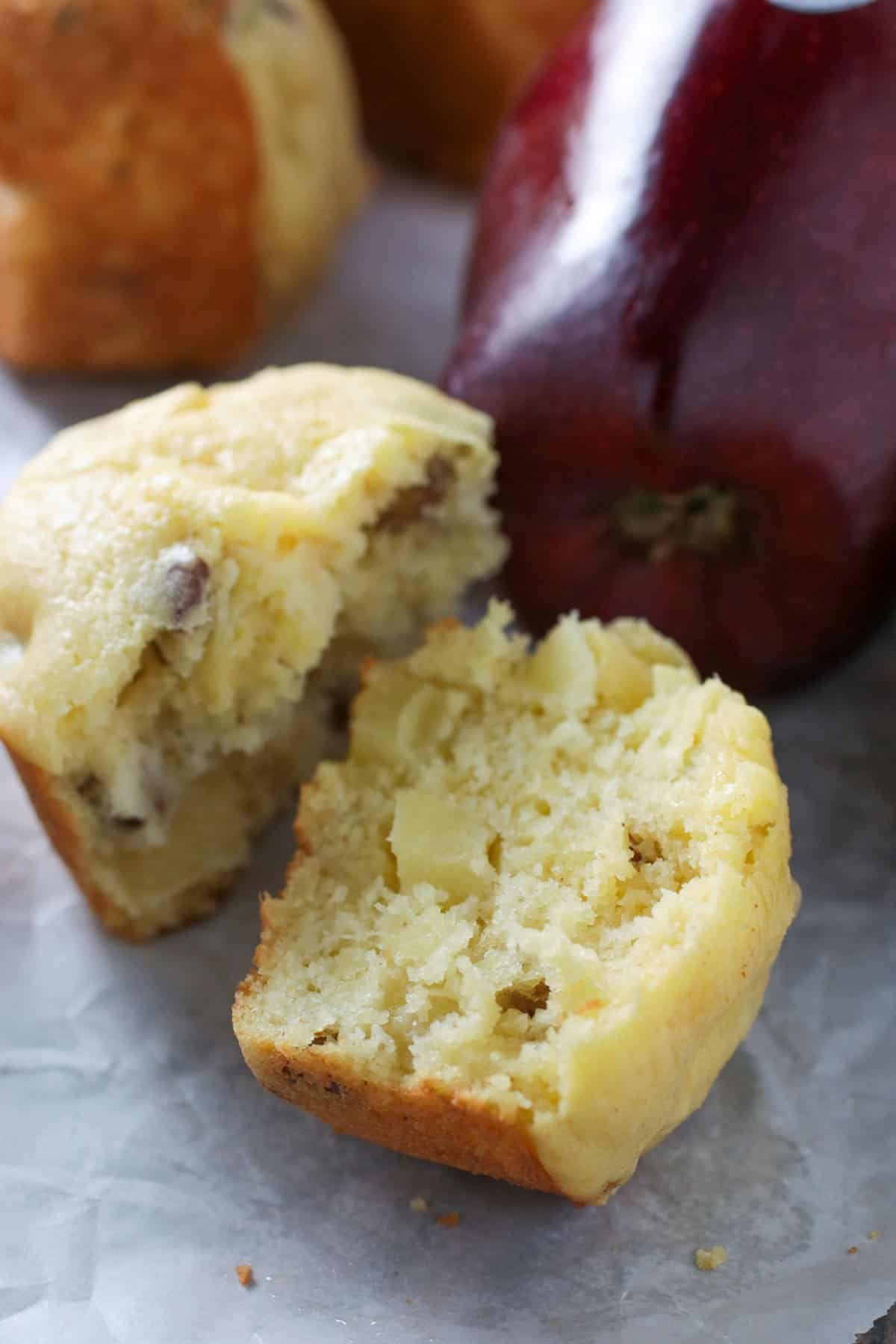 An Apple cornbread muffin sliced in half to show crumbs.