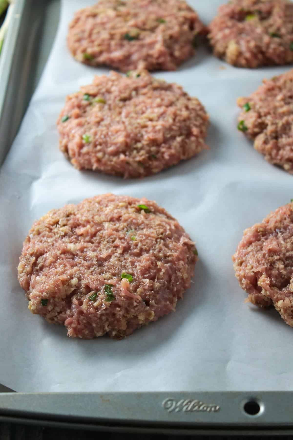The formed chicken burger patties, arranged on a baking tray.