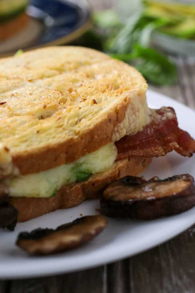 Close up shot of a Swiss Bacon Mushroom Melt sandwich.