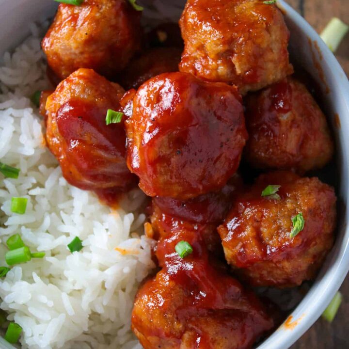 Top shot of baked chicken meatballs in a bowl with rice..