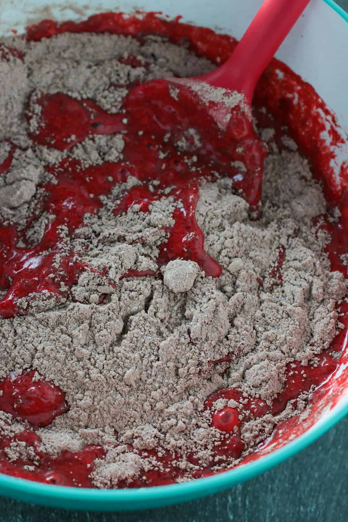 Stirring together the wet and dry mixtures to make the red velvet sheet cake batter.
