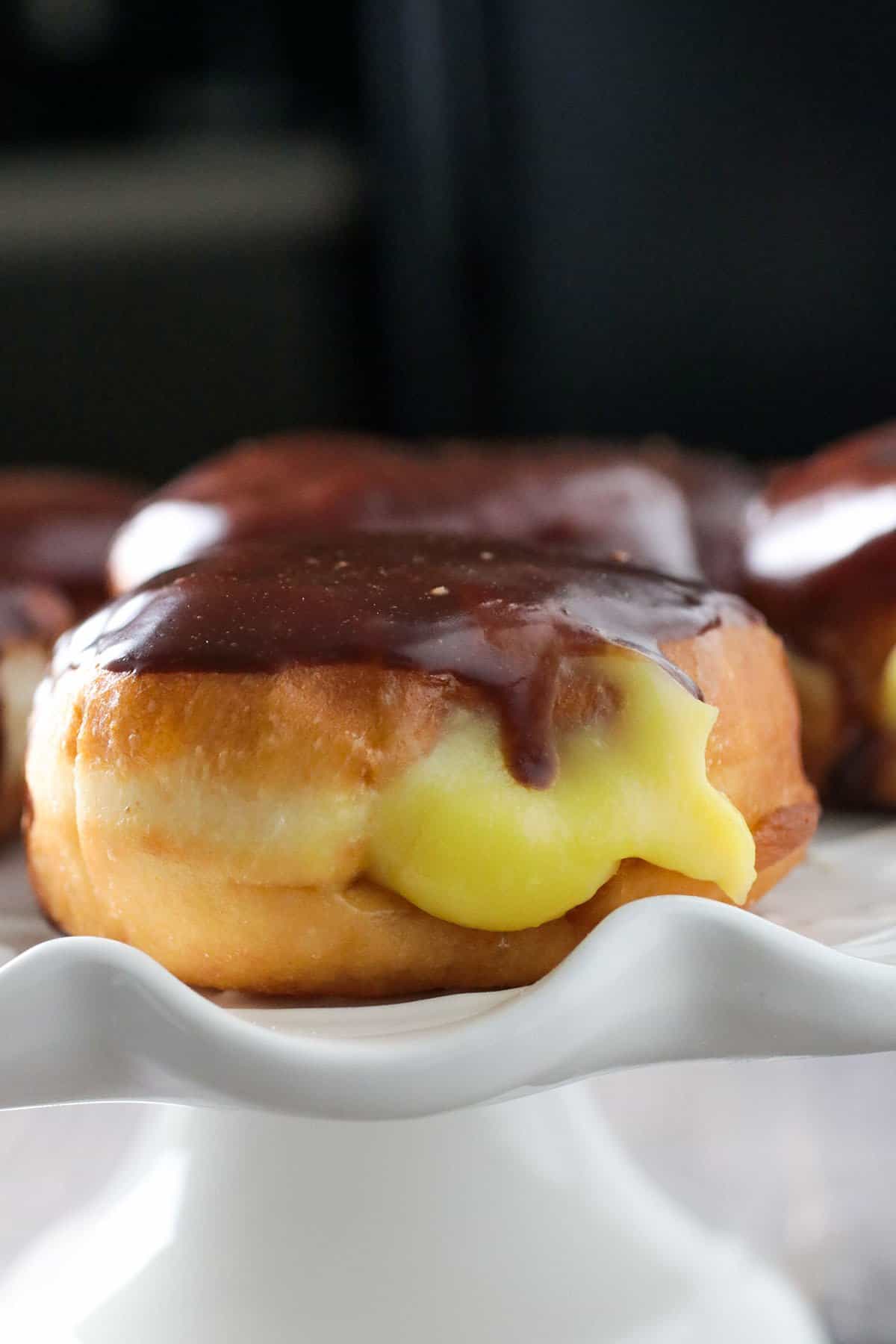 A boston cream donut on a platter.