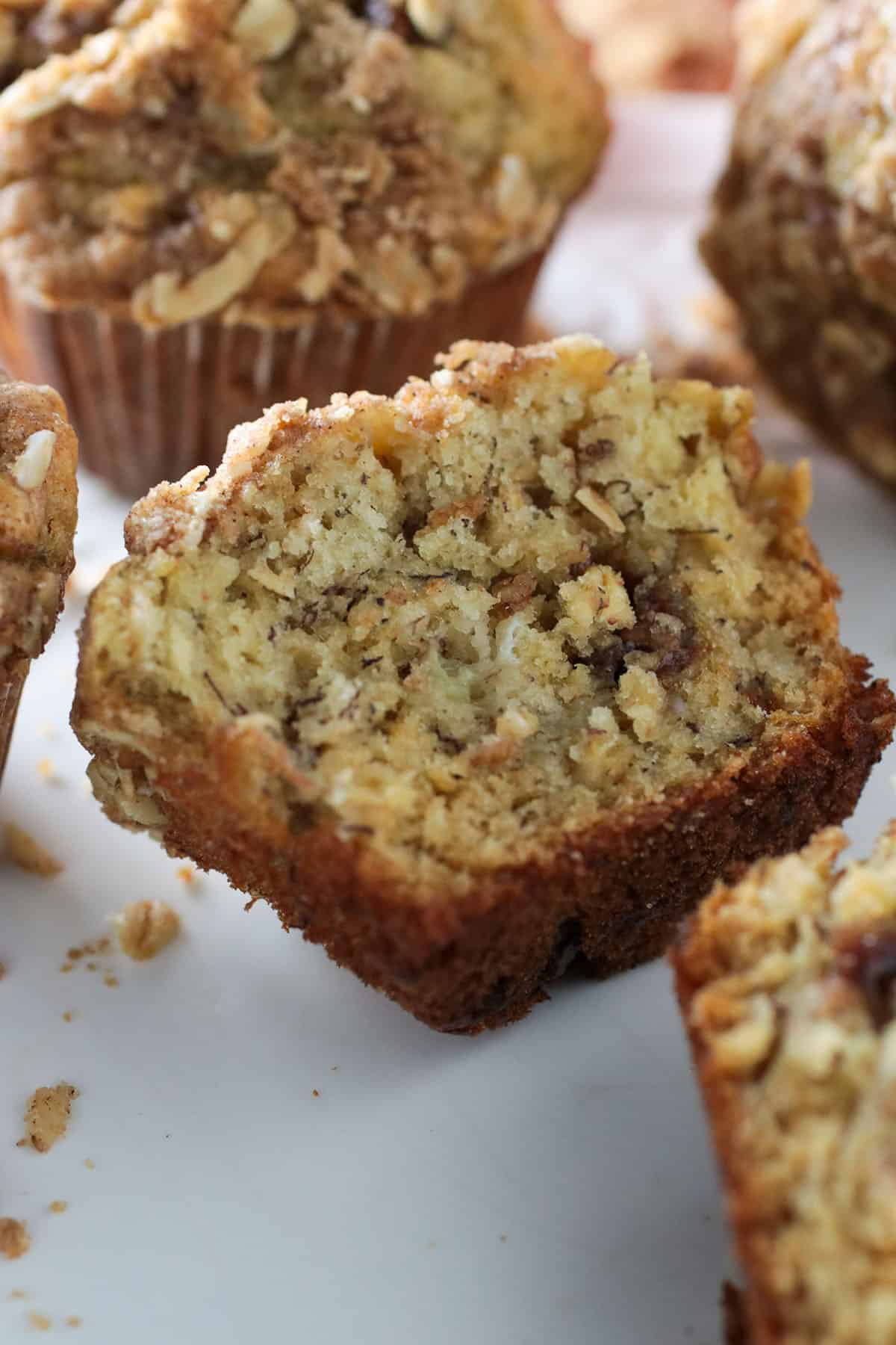 A Banana Chocolate Chip Oatmeal Muffin, sliced in half to show the crumbs.