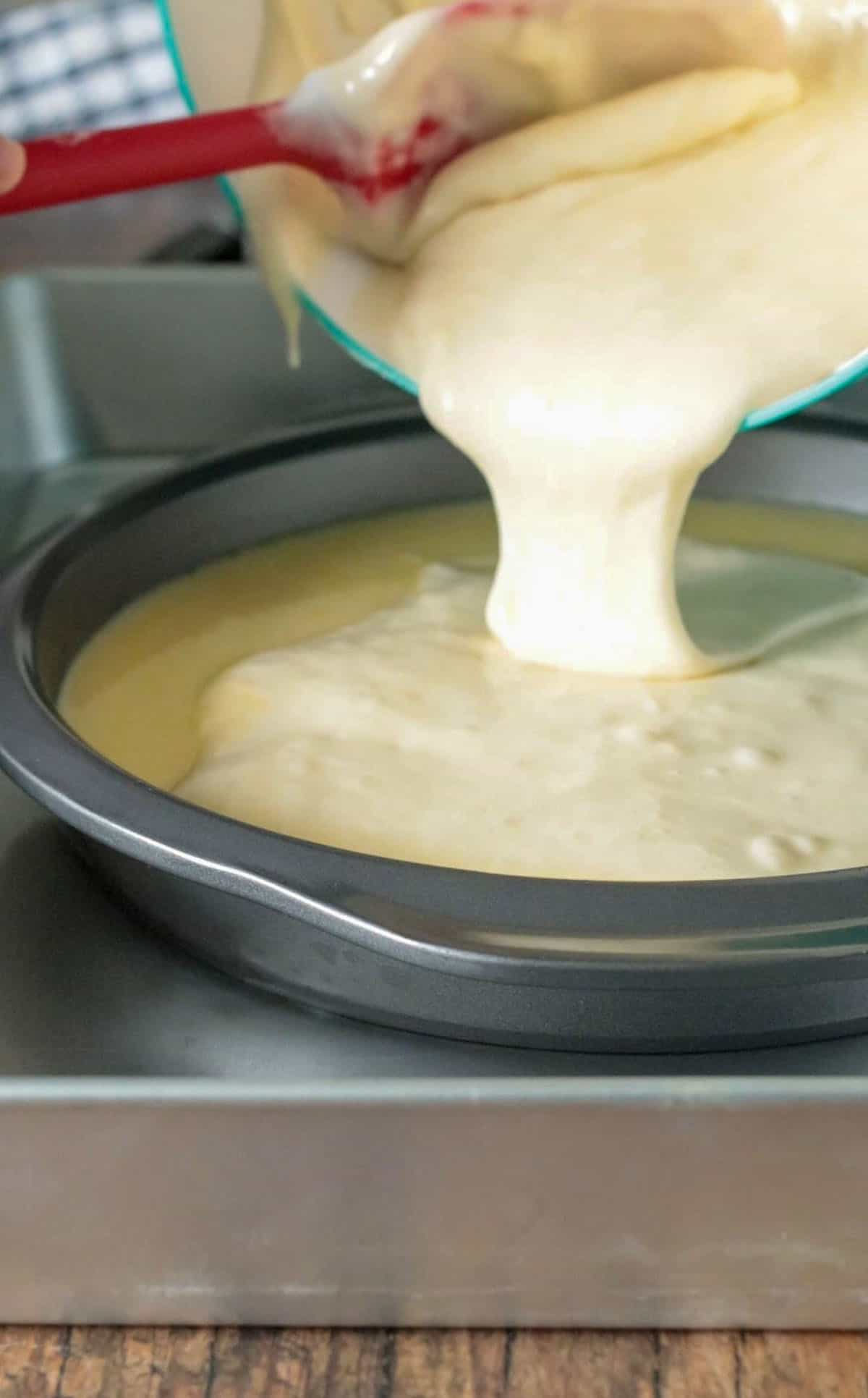 Pouring the chiffon batter over the custard in the pan.