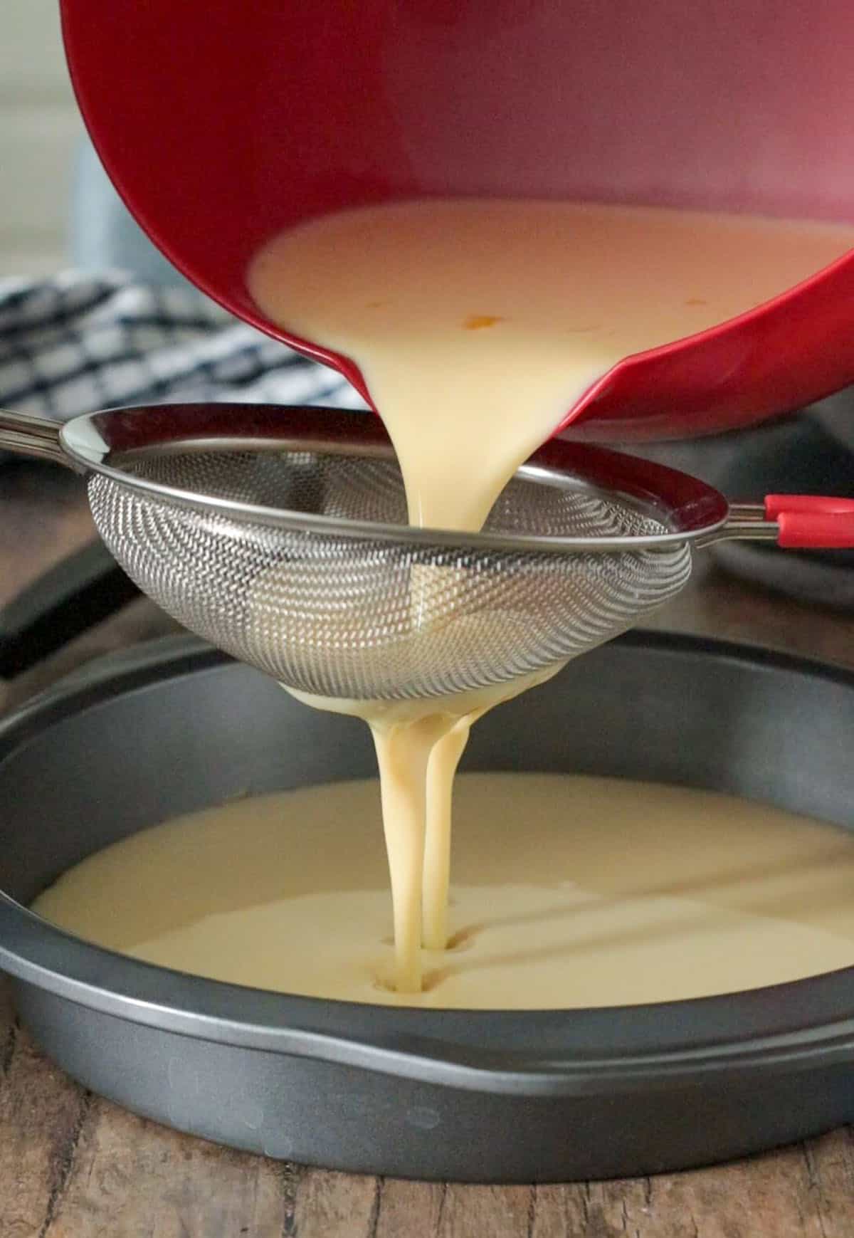 Pouring the custard over the caramel in the pan.