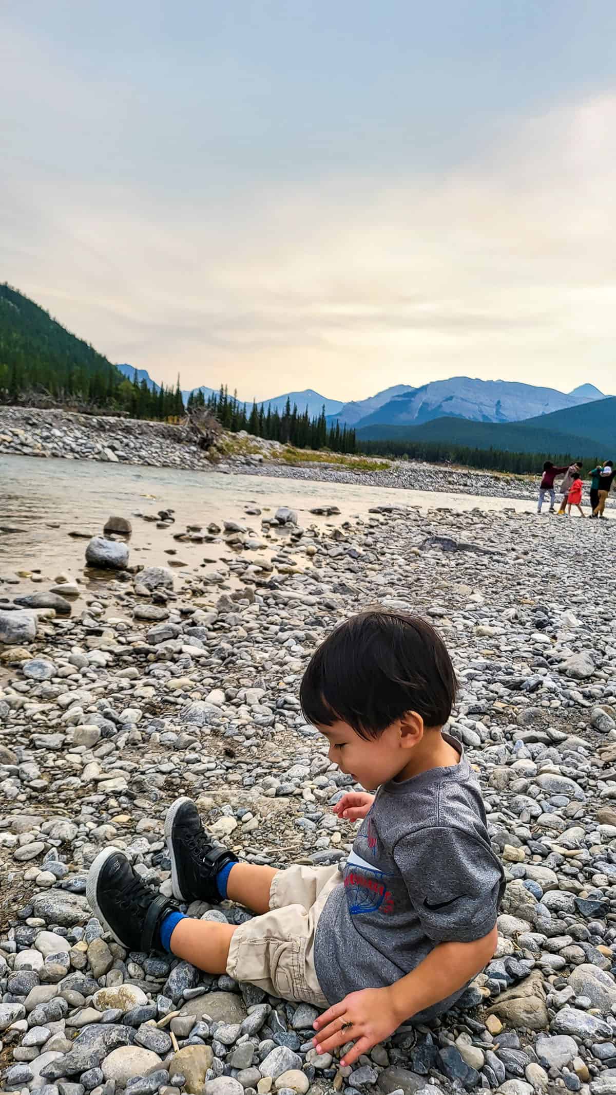 Little boy sitting on mini rocks.