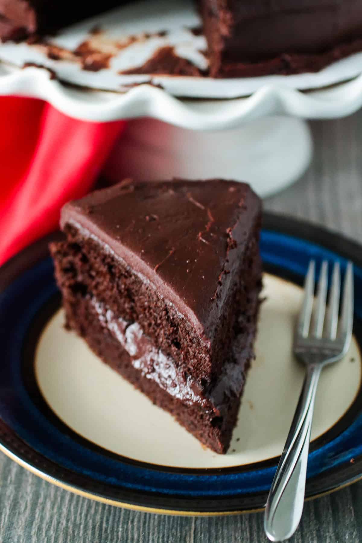 A slice of the chocolate cake on a plate with a fork.