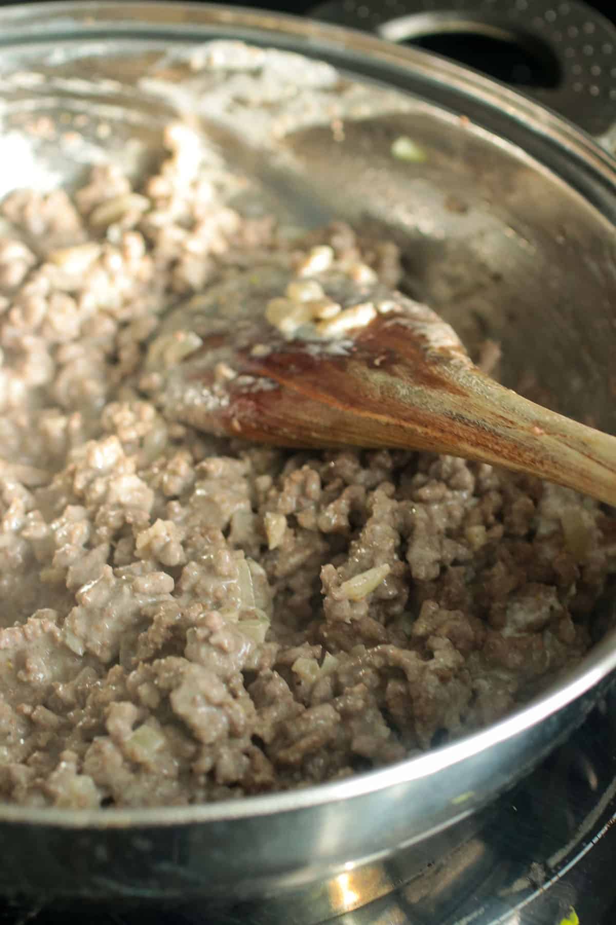 The cooked ground beef in the pan.