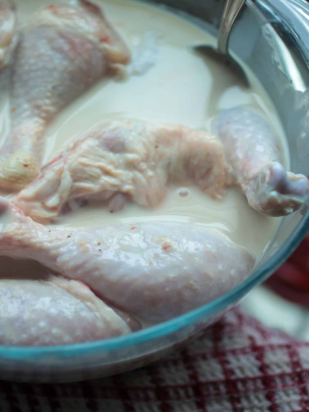 Soaking the chicken in buttermilk mixture.
