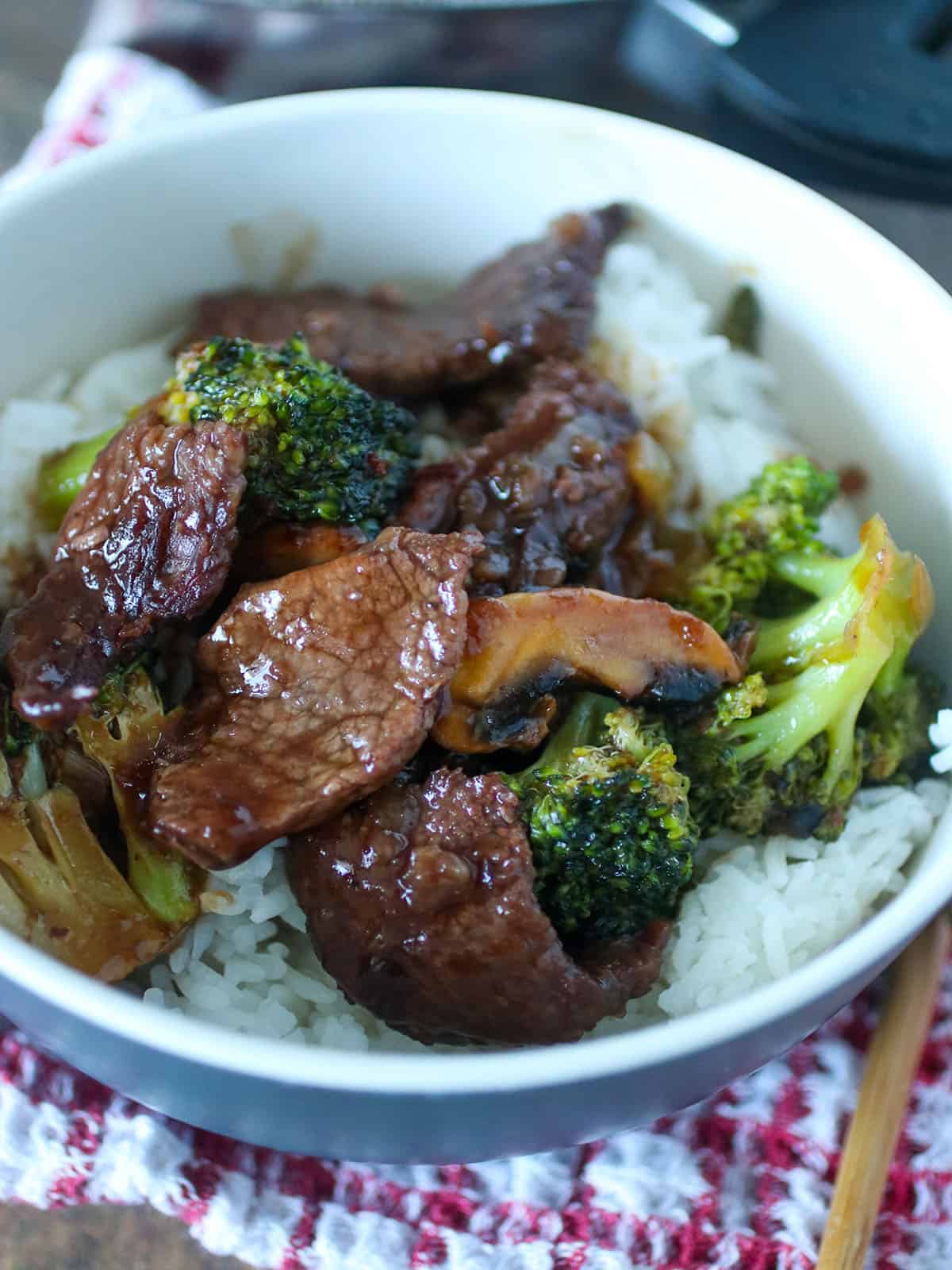 Beef teriyaki with mushrooms and broccoli in a bowl with rice.
