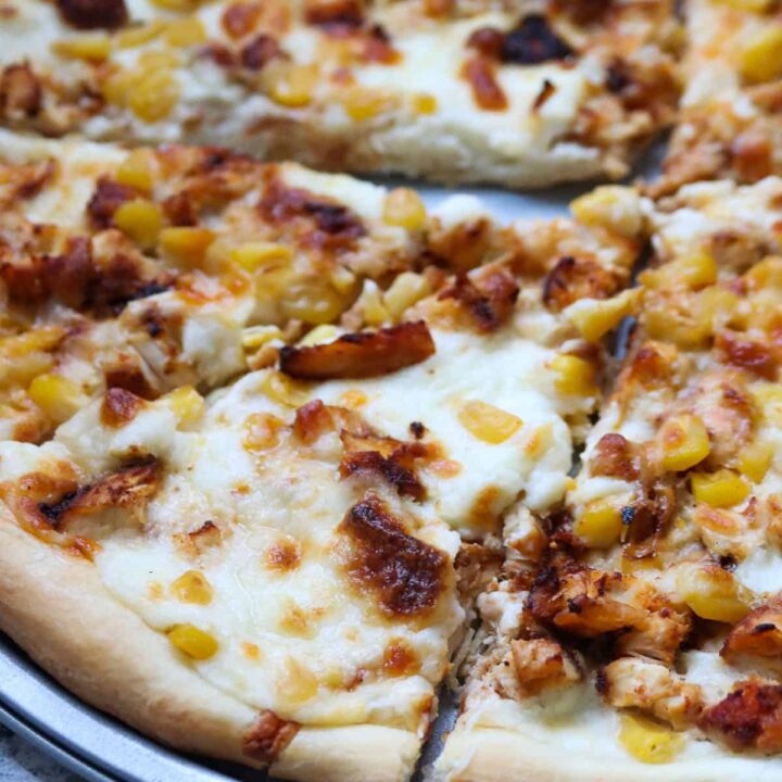 Close up shot of cajun chicken and corn pizza.