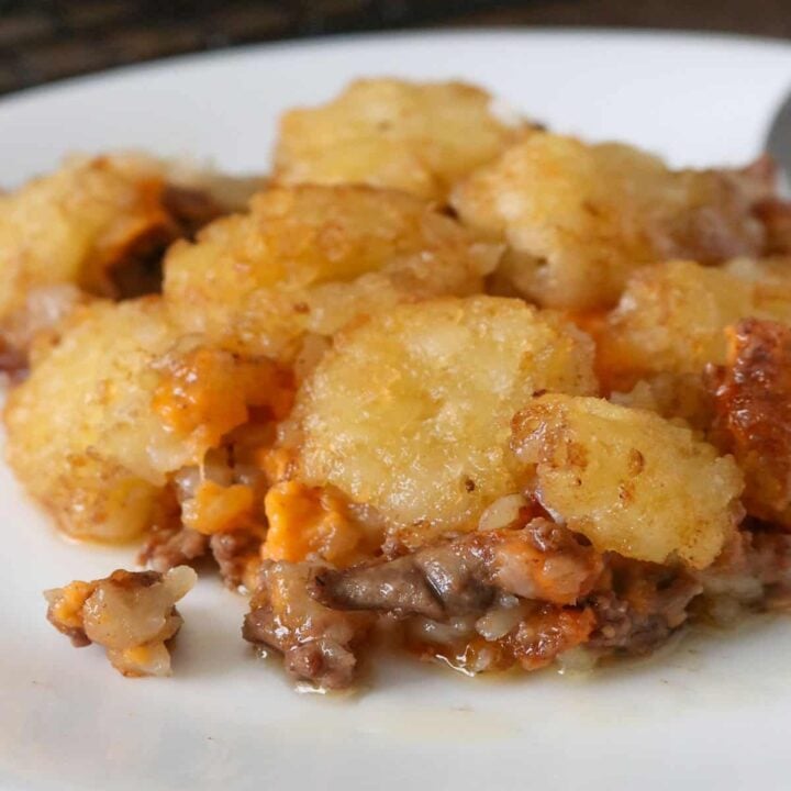 Tater tots with gravy casserole, served on a plate.