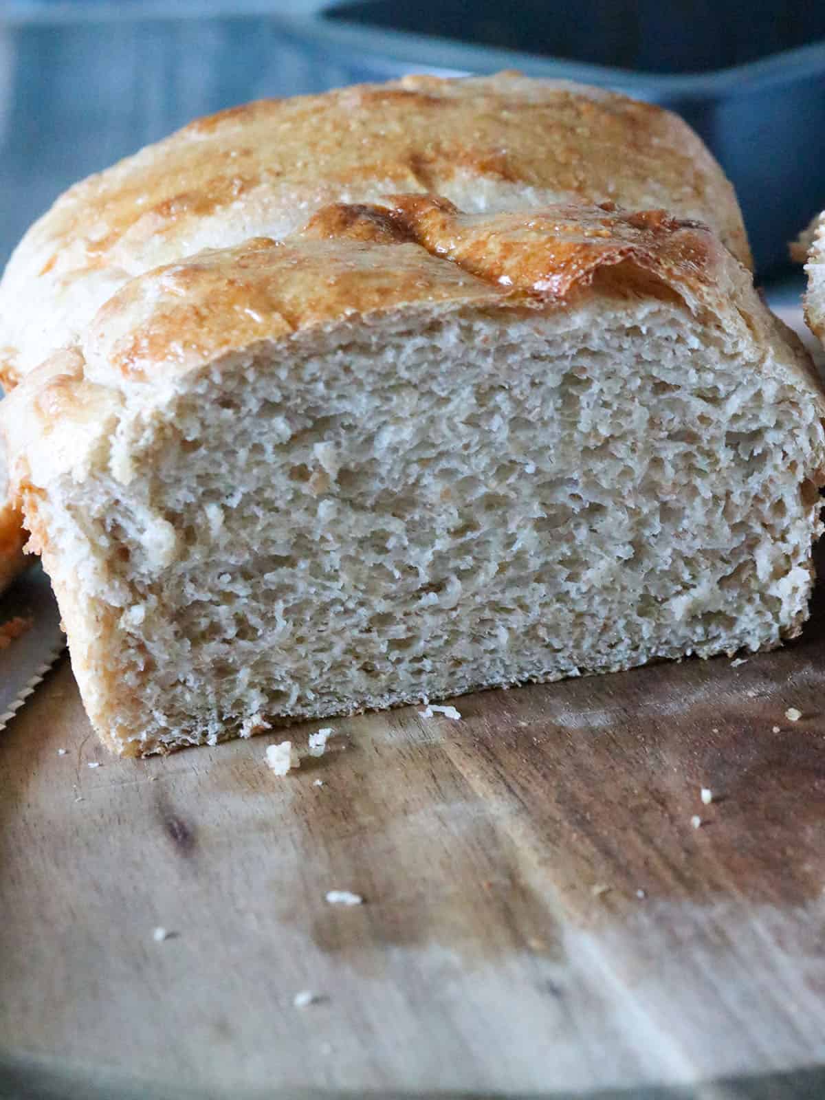 A sliced whole wheat loaf bread on a cutting board.