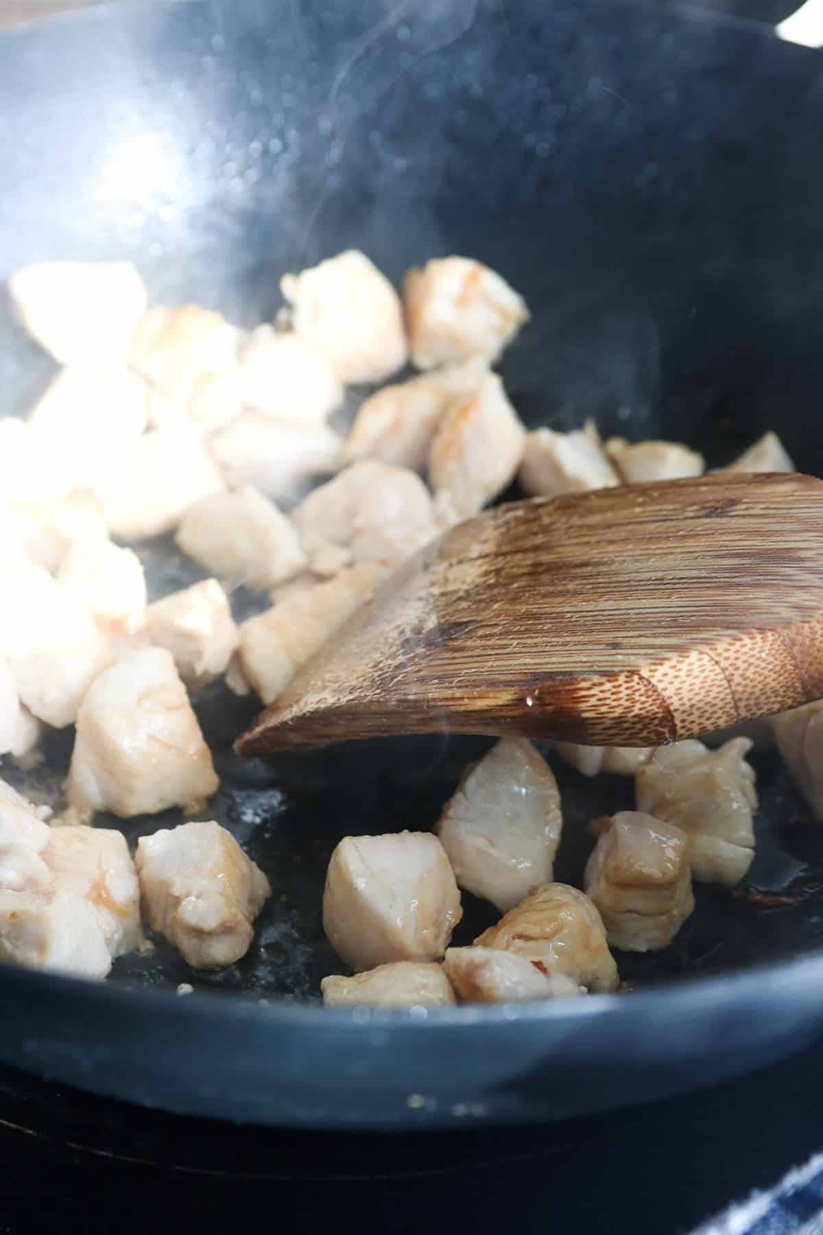 Cooking the chicken pieces in a wok.