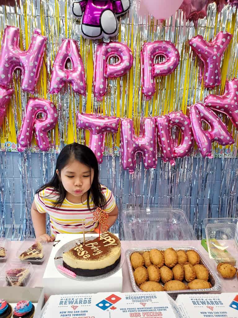 Girl blowing birthday candle.