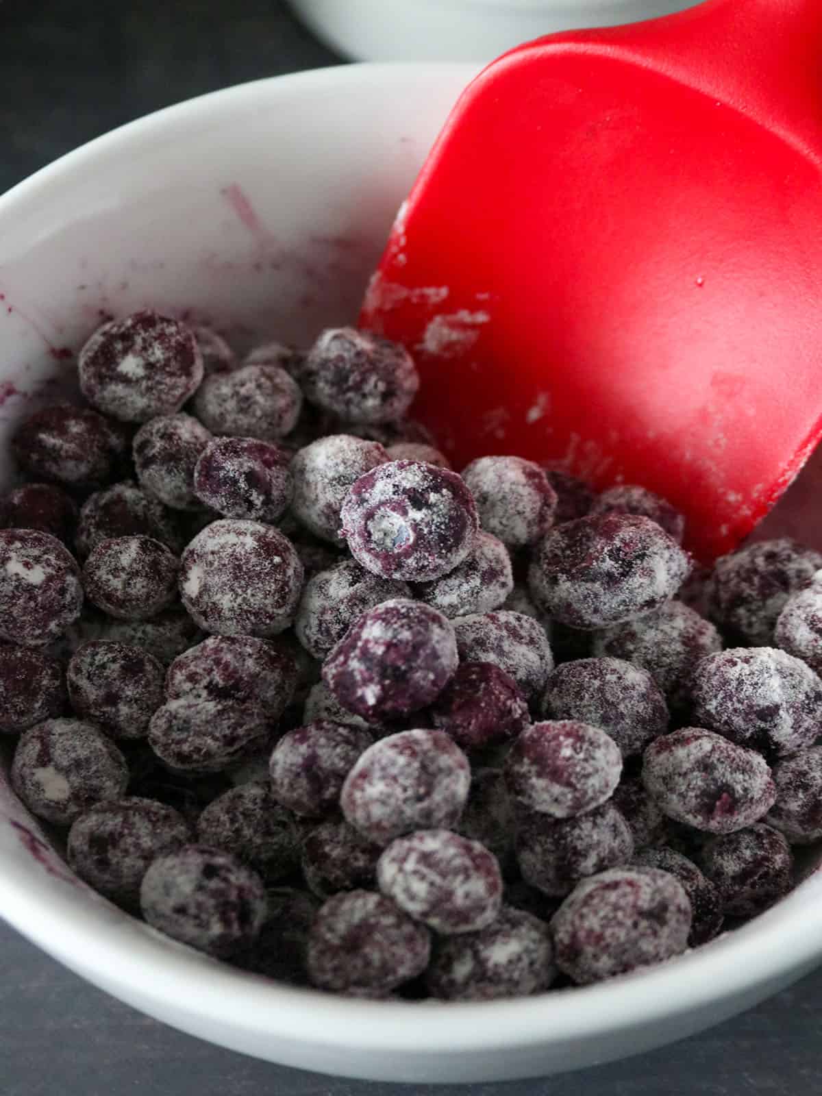 Blueberries in a bowl, coated  lightly with flour.