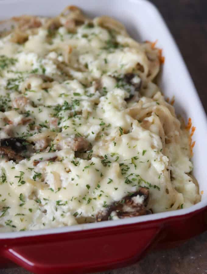 This Creamy Baked Spaghetti with White Sauce is a rich comforting dish flavored with Italian sausage, and mushrooms and lots of cheese!