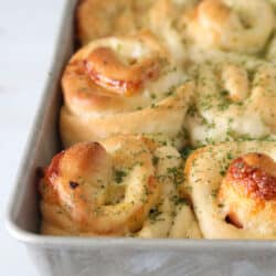 Ham and cheese rolls on a baking pan.