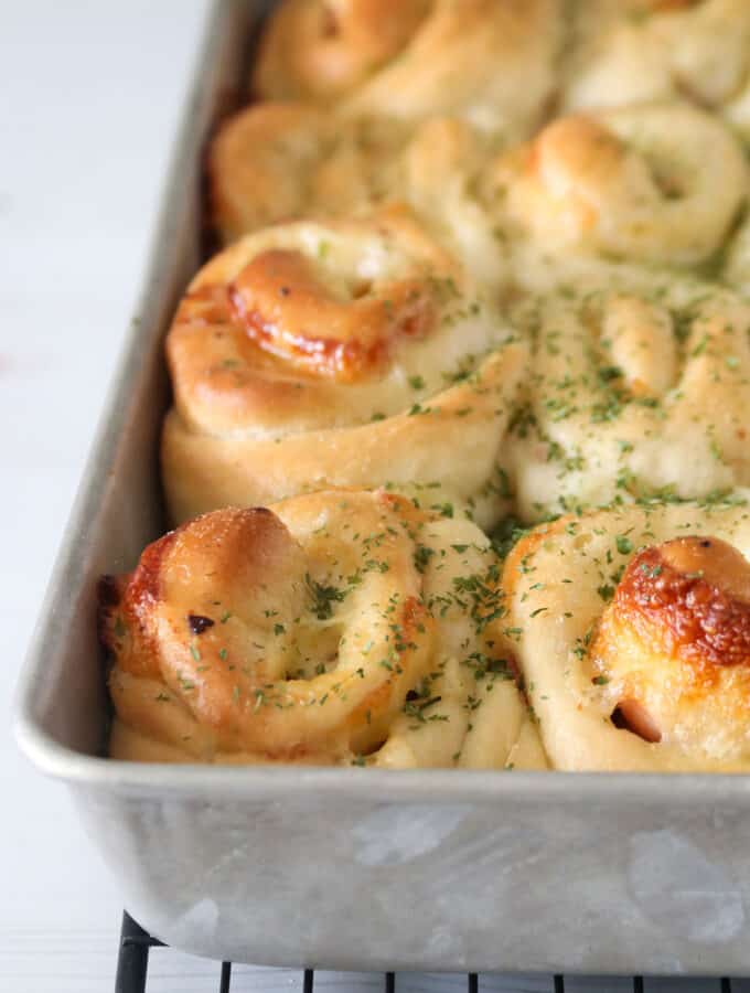 Ham and cheese rolls on a baking pan.