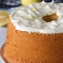 Lemon chiffon cake with frosting on a serving plate.