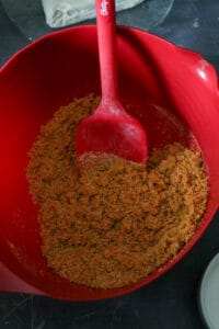 Mixing the graham crumbs and meted butter in a bowl.