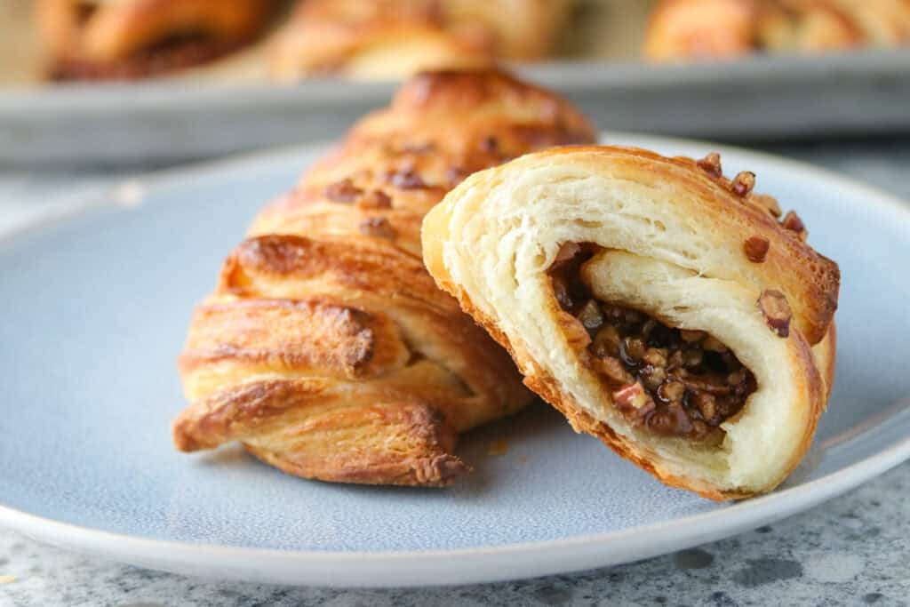 A close up shot of a cut maple pecan Danish pastry.