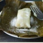 Suman in a banana leaf, dusted with sugar.