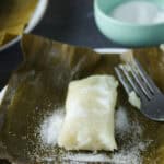 Suman in a banana leaf, dusted with sugar.