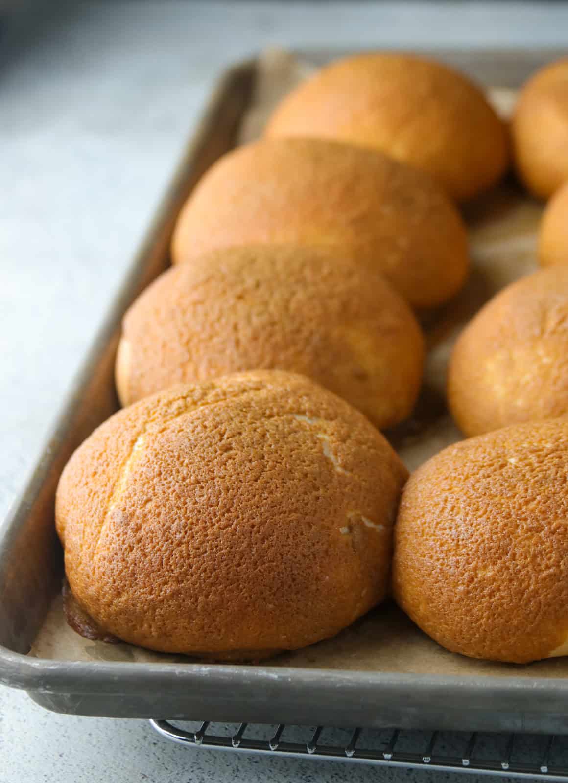 Freshly baked coffee buns on a baking pan.